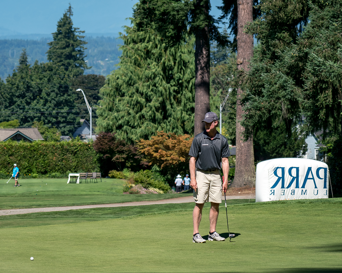 A large Parr Lumber sponsor sign in the background of a golf tournament
